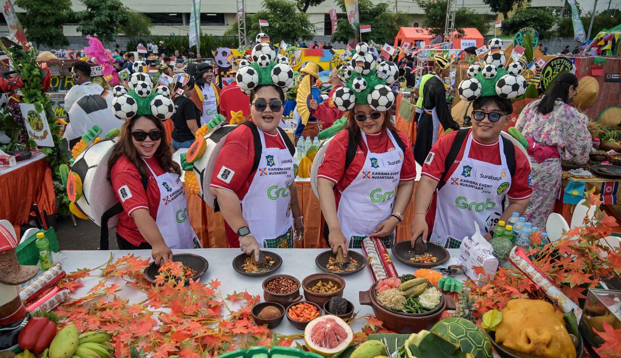  Festival Rujak Menyambut Pesta Sepak Bola Dunia” ini diikuti 136 tim dari komunitas, instansi pemerintah, dan swasta. Tampak dalam foto, para peserta yang mengenakan bola sepak di kepala berpose untuk foto sambil menyiapkan rujak uleg, salad gurih tradisional Indonesia yang berisi moncong sapi dan sayuran, dalam Festival Rujak Uleg 2026 di Surabaya, Jawa Timur, Sabtu 9 Mei 2026. (JUNI KRISWANTO/AFP)