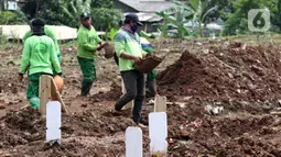 Petugas menyiapkan dan merapikan area khusus pemakaman jenazah dengan protokol COVID-19 di TPU Srengseng Sawah Dua, Jakarta, Selasa, (2/2/2021). TPU Srengseng Sawah 2, saat ini mulai menerima pemakaman jenazah protokol COVID-19 dengan kapasitas 1.020 petak. (Liputan6.com/Helmi Fithriansyah)