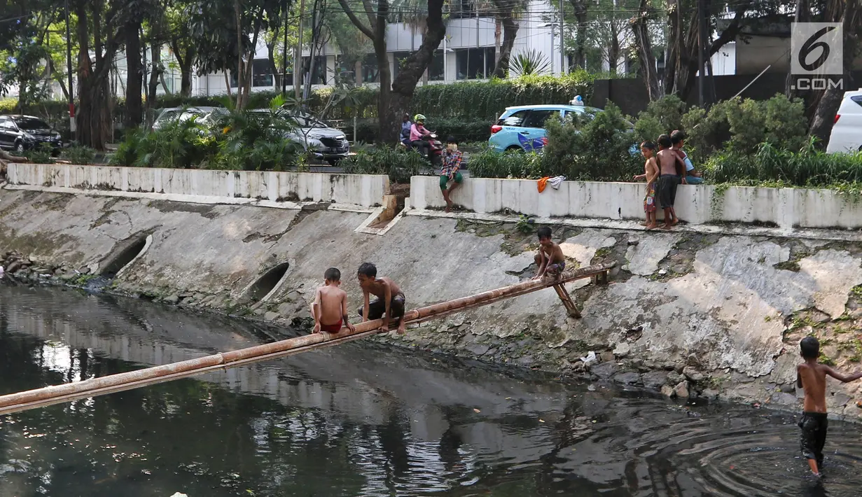 Anak-anak bermain di Kali Gresik di Jalan Muhammad Yamin, Menteng, Jakarta, Rabu (3/7/2019). Minimnya fasilitas bermain gratis, membuat anak-anak tersebut bermain ditempat yang tidak selayaknya. (Liputan6.com/Johan Tallo)