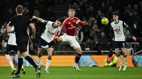 Bek Tottenham Hotspur asal Rumania #06 Radu Dragusin (C) berebut bola dengan penyerang Manchester United asal Denmark #09 Rasmus Hojlund selama pertandingan perempat final Piala Liga Inggris antara Tottenham Hotspur dan Manchester United di Stadion Tottenham Hotspur di London, pada 19 Desember 2024.Ben STANSALL / AFP