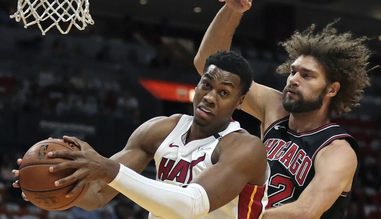 Pemain Miami Heat, Hassan Whiteside (kiri) berusaha mencetak poin saat diadang pemain  Chicago Bulls, Robin Lopez pada laga NBA basketball game, di American Airlines Arena, Miami, (29/3/2018). Heat menang 103-92. (AP/Joel Auerbach)