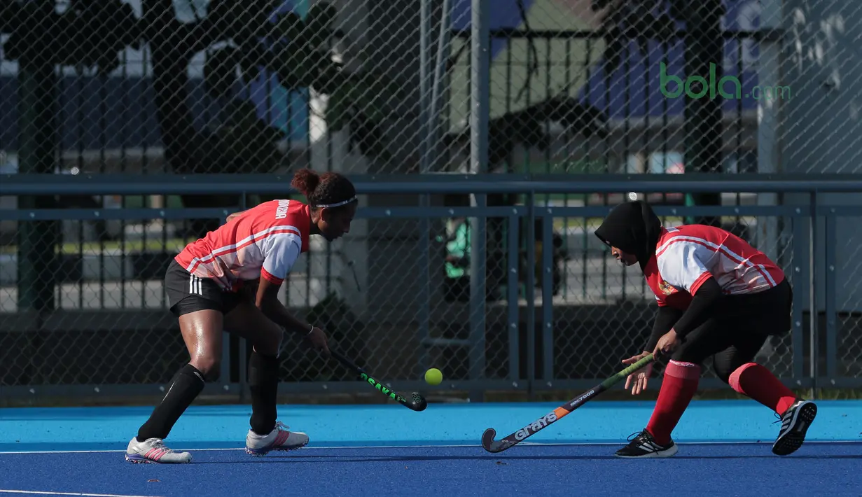 Aksi dua pemain timnas Hoki Putri Indonesia berebut bola pada sesi latihan di Lapangan Hoki, Senayan, Jakarta, Selasa (2/4/2018). Tim Hoki terus melakukan persiapan jelang Asian Games 2018. (Bola.com/Nick Hanoatubun)