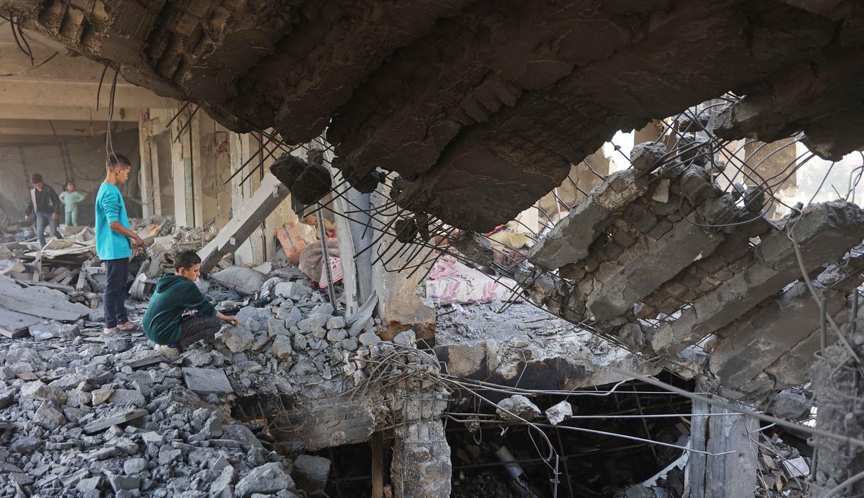 Serangan udara Israel juga menghantam sebuah bangunan yang digunakan sebagai tempat penampungan bagi pengungsi di kawasan Al-Zeitoun, selatan Kota Gaza. Tampak dalam foto, anak-anak Palestina memeriksa puing-puing bangunan yang rusak milik Kementerian Wakaf Agama, yang digunakan sebagai tempat penampungan bagi pengungsi di kawasan Zeitoun, Kota Gaza, pada Kamis 20 November 2025, sehari setelah bangunan tersebut menjadi sasaran serangan militer Israel. (Omar AL-QATTAA /AFP)