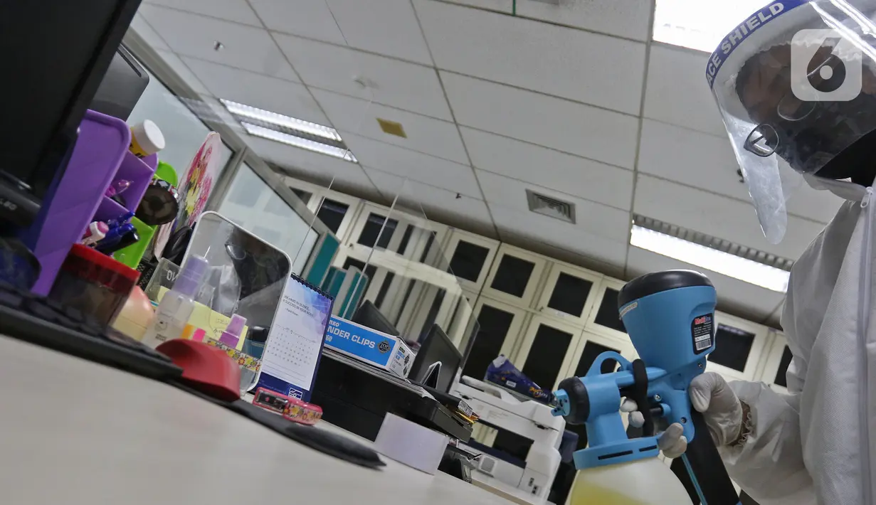 Petugas melakukan penyemprotan cairan disinfektan di meja kerja di Kantor PLN Pusat, Jalan Trunojoyo, Blok M, Jakarta, Selasa (21/7/2020). PT PLN (Persero) menyemprotkan cairan disinfektan secara rutin dan berlaku protokol kesehatan selama pandemi COVID 19. (Liputan6.com/Herman Zakharia)