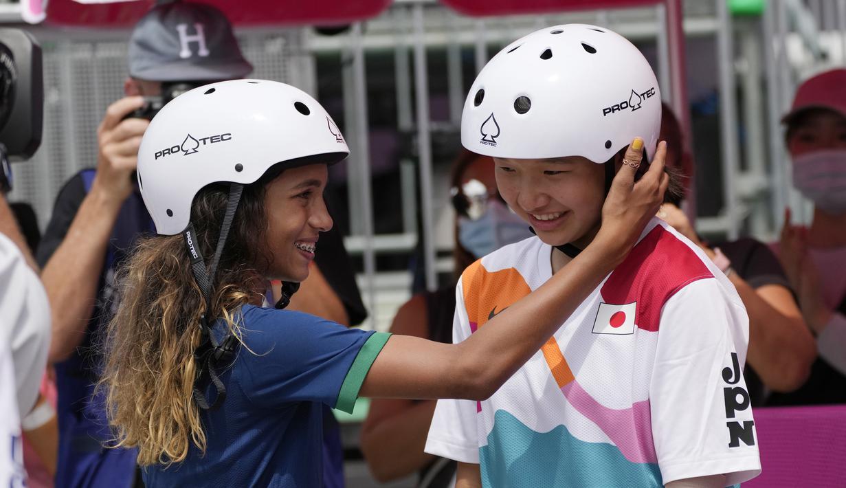 Skater Brasil Rayssa Leal (kiri) memberi selamat kepada skater Jepang Momiji Nishiya setelah memenangkan final street skateboarding putri Olimpiade Tokyo 2020 di Tokyo, Jepang, 26 Juli 2021. Momiji meraih medali emas Olimpiade saat berusia 13 tahun dan 330 hari. (AP Photo/Ben Curtis)