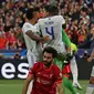 Kiper Real Madrid, Thibaut Courtois (tengah) melakukan selebrasi bersama rekannya usai berhasil menepis tendangan dari pemain Liverpool, Mohamed Salah saat laga final Liga Champions antara Liverpool melawan Real Madrid yang berlangsung di Stade de France, Saint Denis, Sabtu, 28 Mei 2022 waktu setempat. (AFP/Paul Ellis)