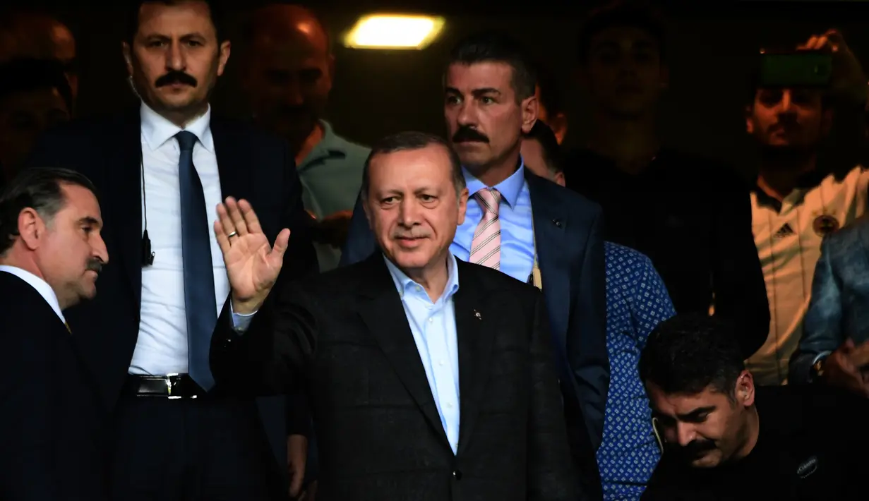 Presiden Turki Recep Tayyip Erdogan menyapa para suporter saat pertandingan Fenerbahce melawan Sturm Graz di Stadion Ulker Fenerbahce di Istanbul (3/8). Fenerbahce menang dengan agregat 3-2. (AFP Photo/Ozan Kose)