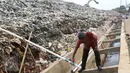 Peneliti mengecek pipa instalasi pengolahan bahan bakar gas metan di TPA Cipayung, Depok, Jumat (3/6). Pemanfaatan gas metan itu diharapkan mampu digunakan semaksimal mungkin untuk menjadi bahan bakar bagi warga sekitar. (Liputan6.com/Immanuel Antonius)