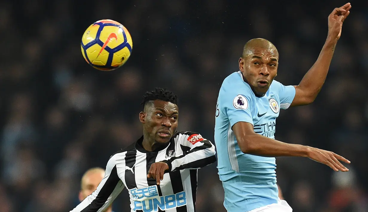 Pemain Newcastle United, Christian Atsu berebut bola dengan pemain Manchester City, Fernandinho pada pertandingan pekan ke-24 Premier League di Etihad Stadium, Minggu (21/1). Manchester City menang telak 3-1 berkat hattrick Sergio Aguero. (AP/Rui Vieira)