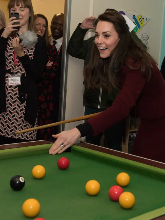 Ekspresi Kate Middleton saat bermain biliar dalam kunjungannya ke MIST, sebuah proyek kesehatan mental bagi anak dan remaja di Pontypool, Wales, Inggris, Inggris (22/2). (AFP Photo / Pool / Paul Edwards)
