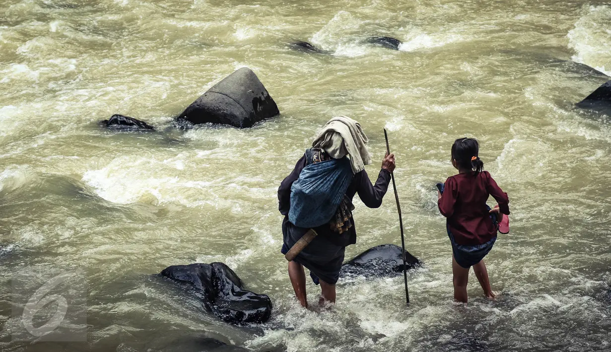 Seorang nenek dan anak Baduy Luar bersiap menyebrangi Kali Ciujung yang cukup deras di Kampung Balimbing, Kabupaten Lebak, Banten, Jumat (13/05). (Liputan6.com/Fery Pradolo)