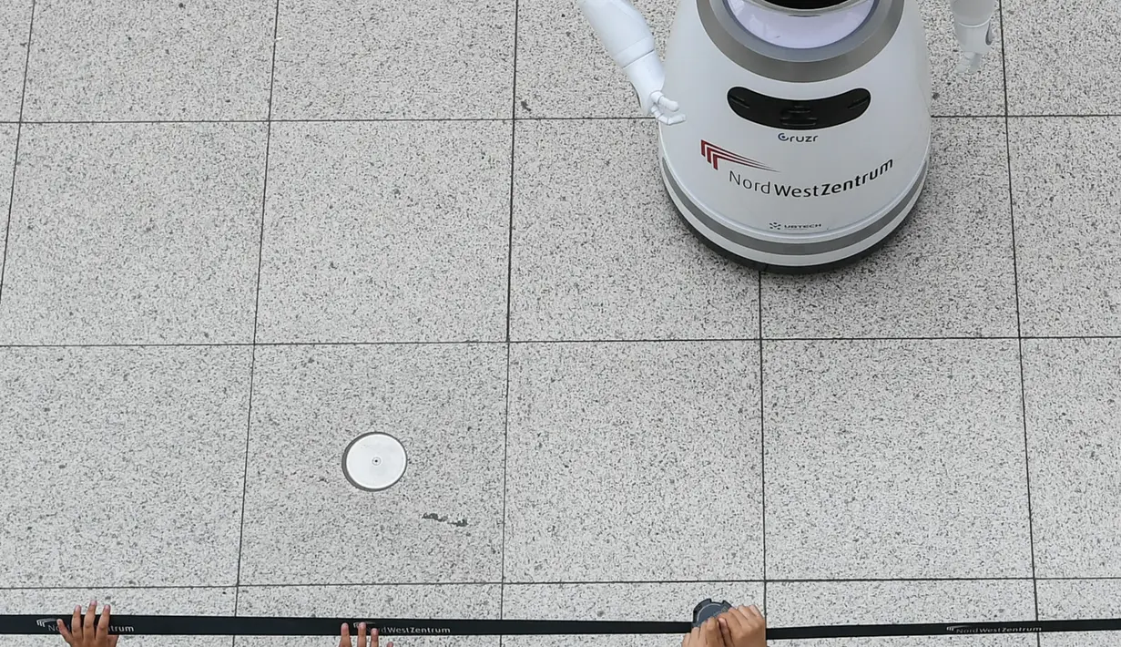 Anak-anak mengamati sebuah robot pintar yang menjelaskan tentang langkah pencegahan COVID-19 di sebuah pusat perbelanjaan di Frankfurt, Jerman, pada 12 September 2020. (Xinhua/Lu Yang)