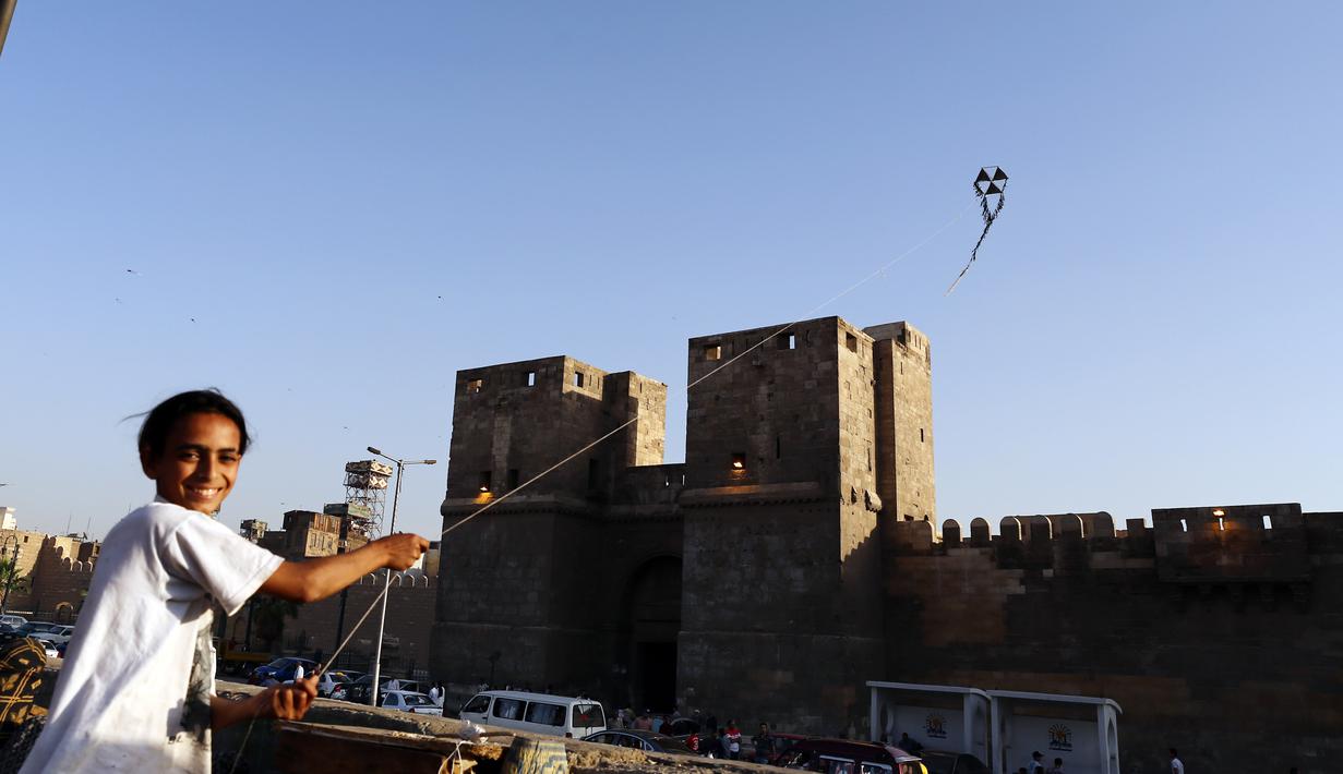 Seorang anak menerbangkan layang-layang di atap sebuah gedung selama masa pandemi COVID-19 di Kairo, Mesir, pada Senin (11/5/2020). Mesir mencatatkan peningkatan harian sebanyak 346 kasus infeksi COVID-19, menambah jumlah kasus terkonfirmasi di negara itu menjadi 9.746. (Xinhua/Ahmed Gomaa)