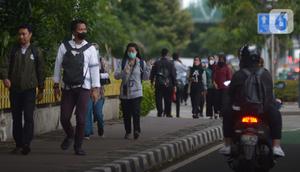 Karyawan perkantoran berjalan kaki  bergegas pulang di Kawasan Sudirman, Jakarta, Rabu (30/11/2022). Keputusan Pemerintah Provinsi (Pemprov) DKI Jakarta menaikan upah minimum provinsi (UMP) DKI  pada 2023 sebesar 5.6 persen menjadi Rp 4,9 juta . ditolak pengusaha dan buruh. (merdeka.com/Imam Buhori)