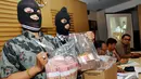 Dua penyidik KPK memperlihatkan uang pecahan Rp100 ribu dalam rilis Operasi Tangkap Tangan (OTT) Ketua DPRD Bangkalan Fuad Amin Imron di Gedung KPK, Jakarta, Selasa (2/12/2014). (Liputan6.com/Miftahul Hayat)