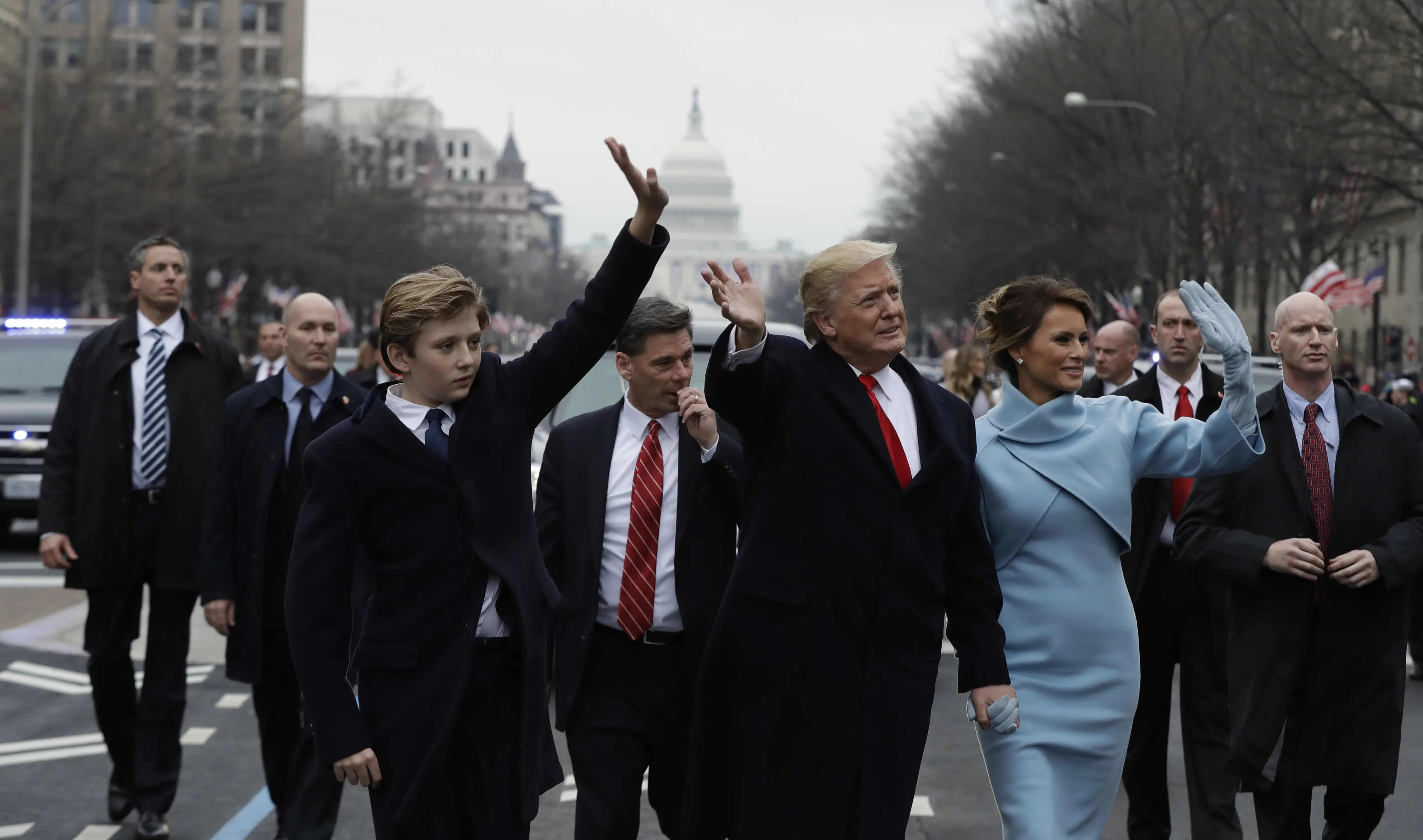 Barron Trump bersama Donald Trump dan Melania melambaikan tangannya ke arah pengunjung saat parade pelantikan di Washington (EVAN VUCCI / POOL / AFP)