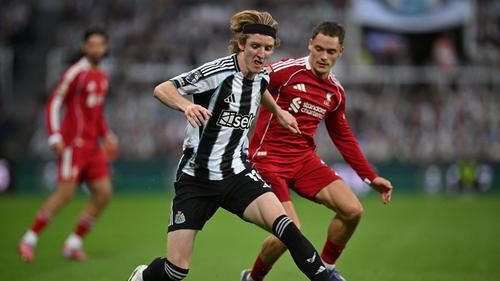 Gelandang Newcastle United, Anthony Gordon, berupaya lepas dari penjagaan pemain Liverpool, Florian Wirtz, pada lanjutan Liga Inggris 2025/2026 di St James' Park, Selasa (26/8/2025) dini hari WIB. (ANDY BUCHANAN / AFP)