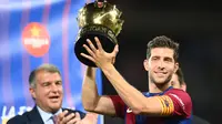 Pemain Barcelona, Sergi Roberto mengangkat trofi Piala Joan Gamper edisi ke-58 setelah mengalahkan Tottenham Hotspur dengan skor 4-2di Estadi Olimpic Lluis Companys, Barcelona, 8 Agustus 2023. (AFP/Pau Barrena)