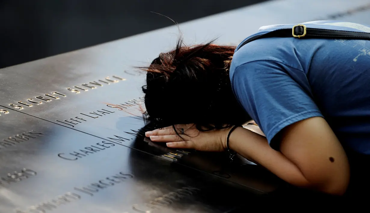 Seorang wanita meletakkan kepalanya saat melihat situs nama-nama para korban peristiwa serangan 11 September 2001 lalu di National September 11 Memorial and Museum at the World Trade Center, New York, Sabtu (10/9). (REUTERS/Mark Kauzlarich)