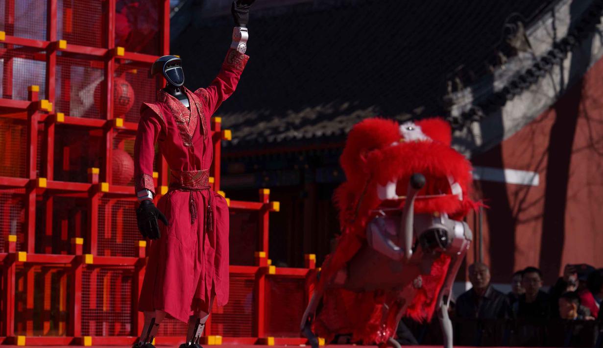 Pertunjukan ini merupakan bagian dari tren "AI Temple Fair". Tampak dalam foto, sebuah robot humanoid dengan pakaian merah meriah memberi isyarat di atas panggung sementara robot berkaki empat yang dilengkapi kepala singa bergerak di latar depan selama hari kedua perayaan Tahun Baru Imlek 2577 Kongzili di sebuah pekan raya kuil di Beijing pada Rabu 18 Februari 2026. (AP Photo/Vincent Thian)