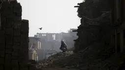 Seorang pria duduk di atas puing-puing rumah yang rusak akibat gempa tahun lalu di Nepal, Jum'at (29/1/2016). Gempa bumi pada bulan April dan Mei 2015 silam menewaskan hampir 9.000 orang dalam bencana alam terburuk Nepal. (Reuters/Navesh Chitrakar)