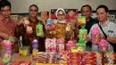 Kepala BPOM Penny K Lukito (tengah) menunjukkan barang bukti saat menggerebek pabrik makanan ringan ilegal atau palsu di Kota Tangerang, Kamis (4/8). Ada 7.000 kardus berhasil diamankan petugas dengan kerugian Rp 400 juta. (Liputan6.com/Gempur M Surya)