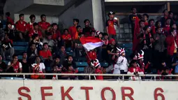 Para suporter terlihat terus mengibarkan Sang Merah Putih saat menyaksikan laga persahabatan Timnas Indonesia U-19 vs Myanmar U-19 di Stadion GBK Jakarta, (5/5/2014). (Liputan6.com/Helmi Fithriansyah)