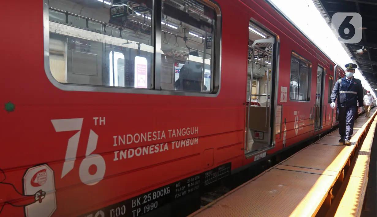 Petugas berjalan di samping Gerbong KAI Commuter bertemakan Kemerdekaan Republik Indonesia ke-76 di Stasiun Kota, Jakarta, Selasa (17/8/2021). Peringatan HUT ke-76 RI tahun 2021, KAI Commuter ikut memeriahkan perayaan tersebut dengan memasang livery khusus. (Liputan6.com/Herman Zakharia)