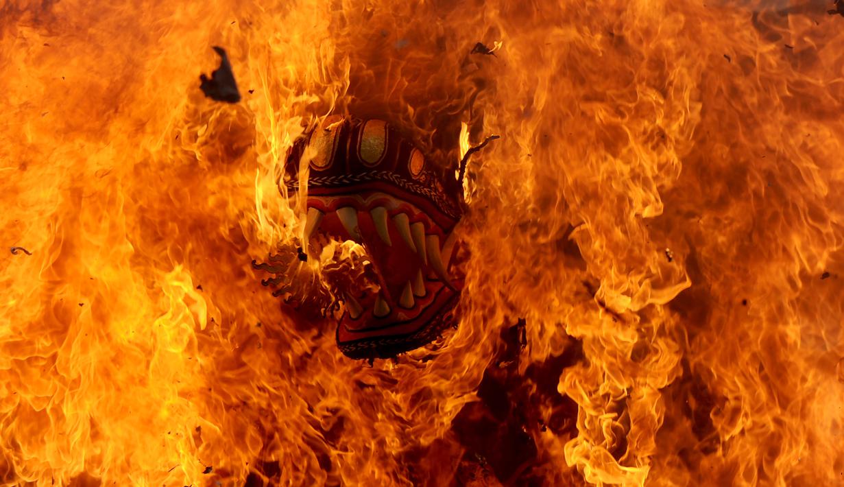 Peti berbentuk naga yang berisi jenazah anggota keluarga dari pahlawan nasional I Gusti Ngurah Rai dibakar dalam prosesi upacara Ngaben di Desa Carangsari, Bali, Senin (29/4/2019). Ribuan waga mengiringi kremasi terhadap jenazah putra kedua dan cucu dari I Gusti Ngurah Rai itu. (SONNY TUMBELAKA/AFP)