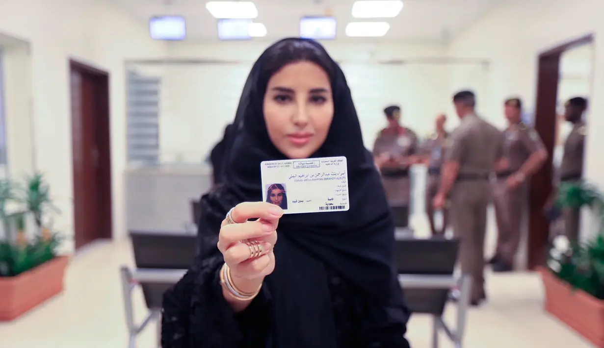 Esraa Albuti menunjukkan surat izin mengemudi (SIM) miliknya di Departemen Lalu Lintas Umum di ibu kota Riyadh, Senin (4/6). Pemerintah Arab Saudi resmi mengeluarkan lisensi mengemudi untuk para wanita di sana. (Saudi Information Ministry via AP)