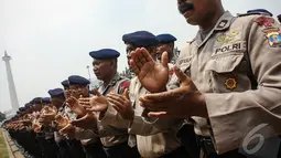 Para Polisi bernyanyi bersama sambil bertepuk tangan untuk memompa semangat saat apel pengamanan pelantikan presiden dan wakil presiden di halaman Monumen Nasional, Jakarta, Jumat (17/10/2014) (Liputan6.com/Faizal Fanani)