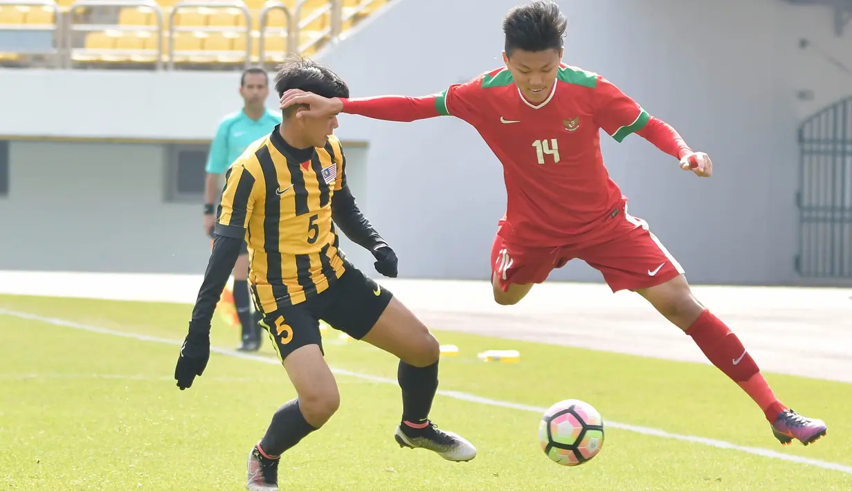 Gelandang Indonesia, Feby Eka Putra, menghindari kejaran pemain Malaysia pada laga Kualifikasi Piala Asia U-19 2018 di Stadion Public, Paju, Senin (6/11/2017). Indonesia kalah 1-4 dari Malaysia. (AFP/Kim Doo-Ho)