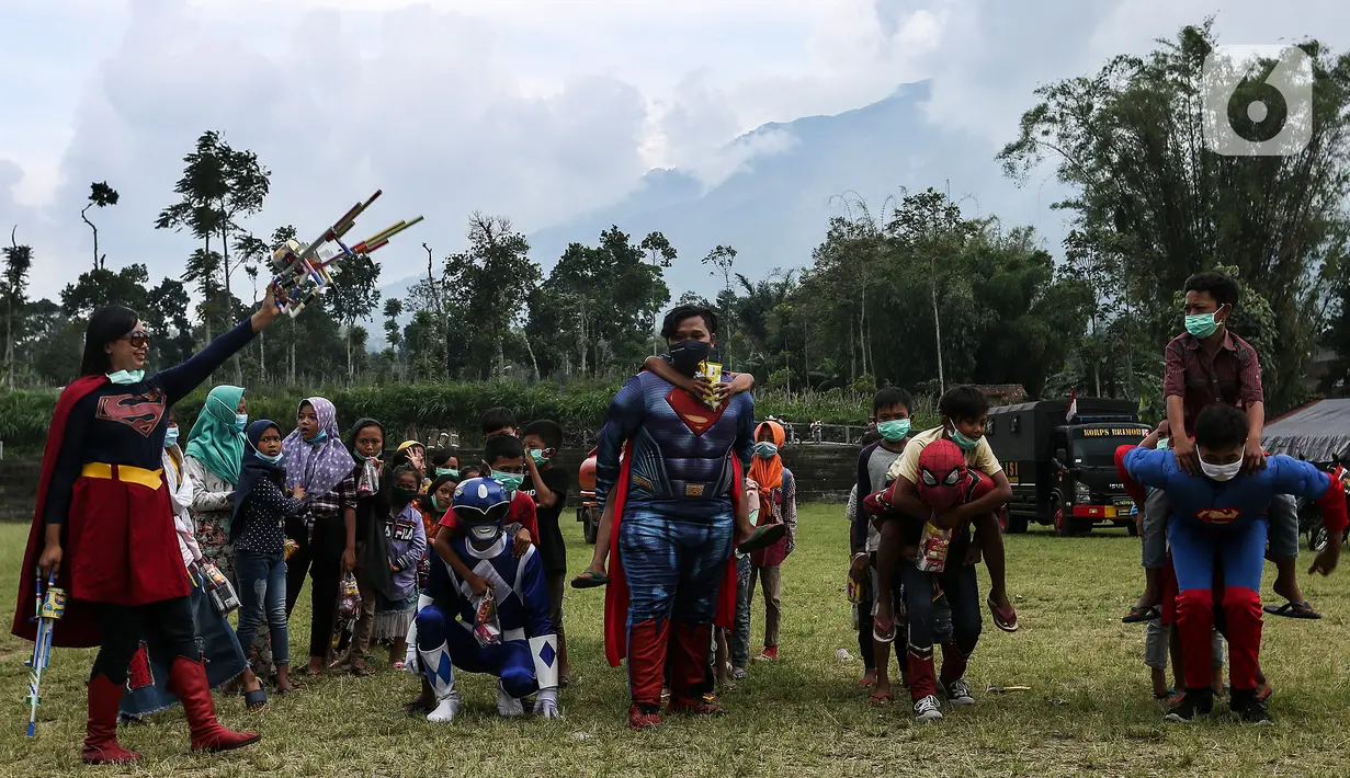 Relawan berkostum superhero bermain dengan anak-anak di Tempat Pengungsian Sementara Gunung Merapi, Desa Klakah, Selo, Boyolali, Jawa Tengah, Sabtu (21/11/2020). Kegiatan bermain ini untuk mengisi waktu anak-anak sehingga dapat menjaga kondisi anak tetap ceria dan sehat. (Liputan6.com/Johan Tallo)