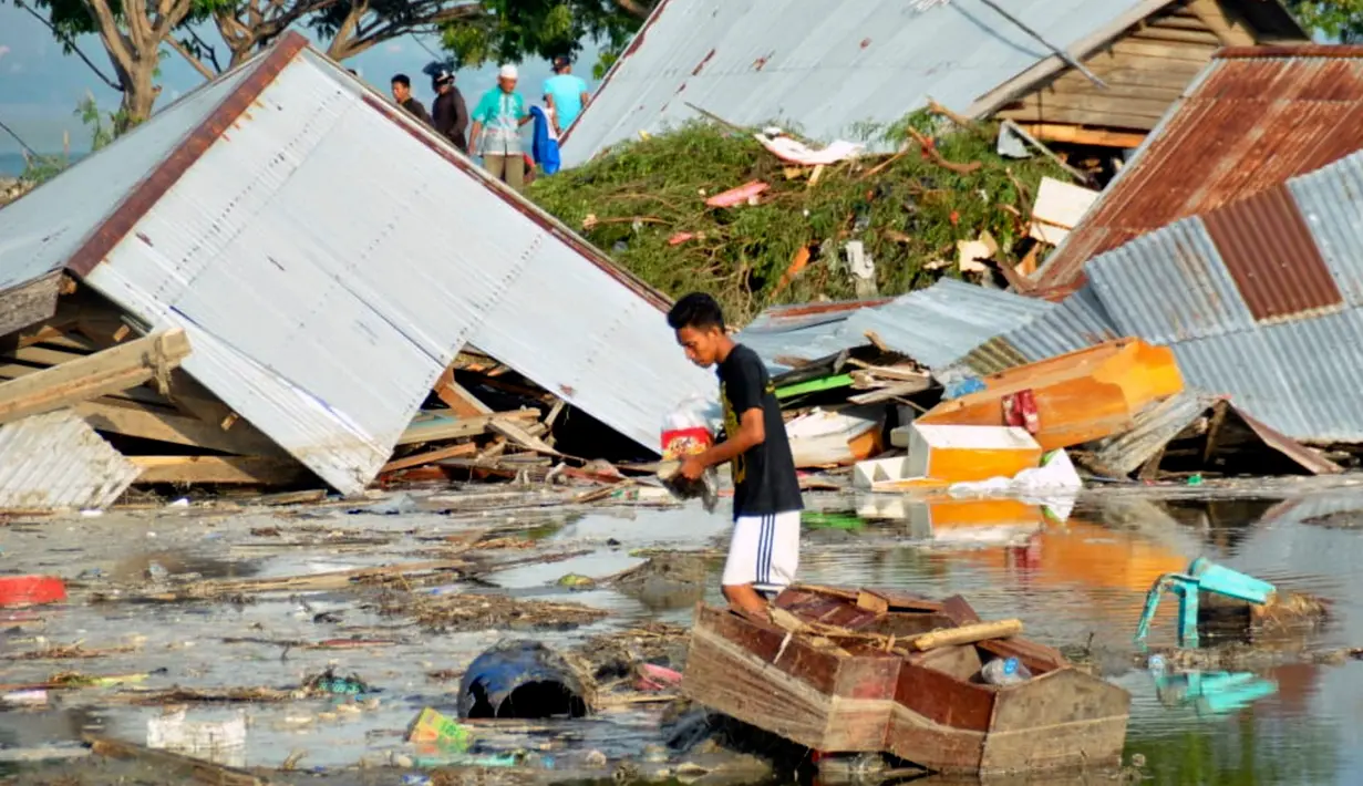 Seorang pria memeriksa kerusakan akibat gempa dan tsunami di Palu, Sulawesi Tengah , Sabtu (29/9). Gelombang tsunami setinggi 1,5 meter yang menerjang Palu terjadi setelah gempa bumi mengguncang Palu dan Donggala. (AP Photo/Rifki)