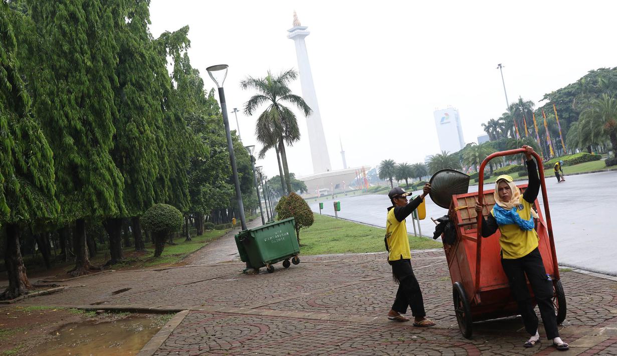 Petugas kebersihan membersihkan sampah di kawasan Monas, Jakarta, Senin (3/11). Kesigapan petugas kebersihan pasca reuni 212 membuat kawasan tersebut kembali bersih meskipun sehari sebelumnya dipenuhi ratusan ribu orang. (Liputan6.com/Immanuel Antonius)