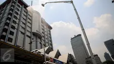 Petugas kebakaran berusaha memadamkan kobaran api yang melanda lantai 14 gedung pusat perbelanjaan Sarinah, Jakarta, Kamis (15/10/2015). Sekitar 21 mobil pemadam kebakaran dikerahkan ke lokasi untuk memadamkan api. (Liputan6.com/Faizal Fanani)