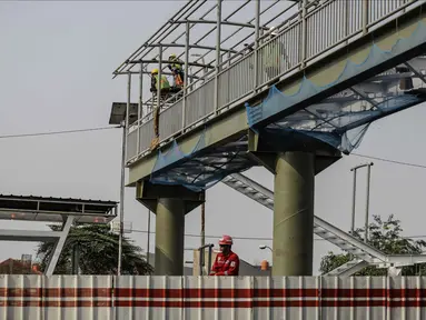 Pekerja menyelesaikan pembangunan halte busway BNN di Kawasan Cawang Jakarta, Jumat (2/3). Pembangunan halte baru tersebut guna menggantikan halte BNN yang lama akibat pembangunan proyek LRT. (Liputan6.com/Faizal Fanani)