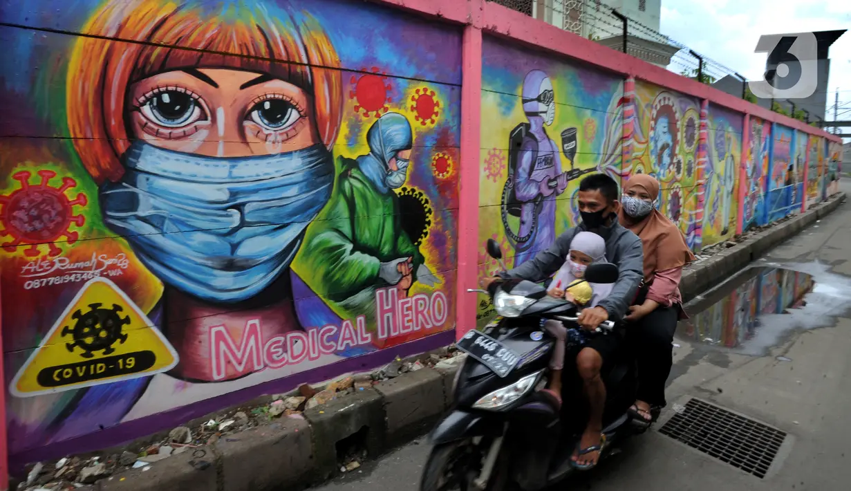 Pengendara sepeda motor melintasi mural bertema COVID-19 di kawasan Tanah Tinggi, Tangerang, Banten, Rabu (20/1/2020). Kegiatan ini dalam rangka mensosialisasikan bahaya penyebaran COVID-19 kepada warga pengguna jalan umum. (merdeka.com/Arie Basuki)