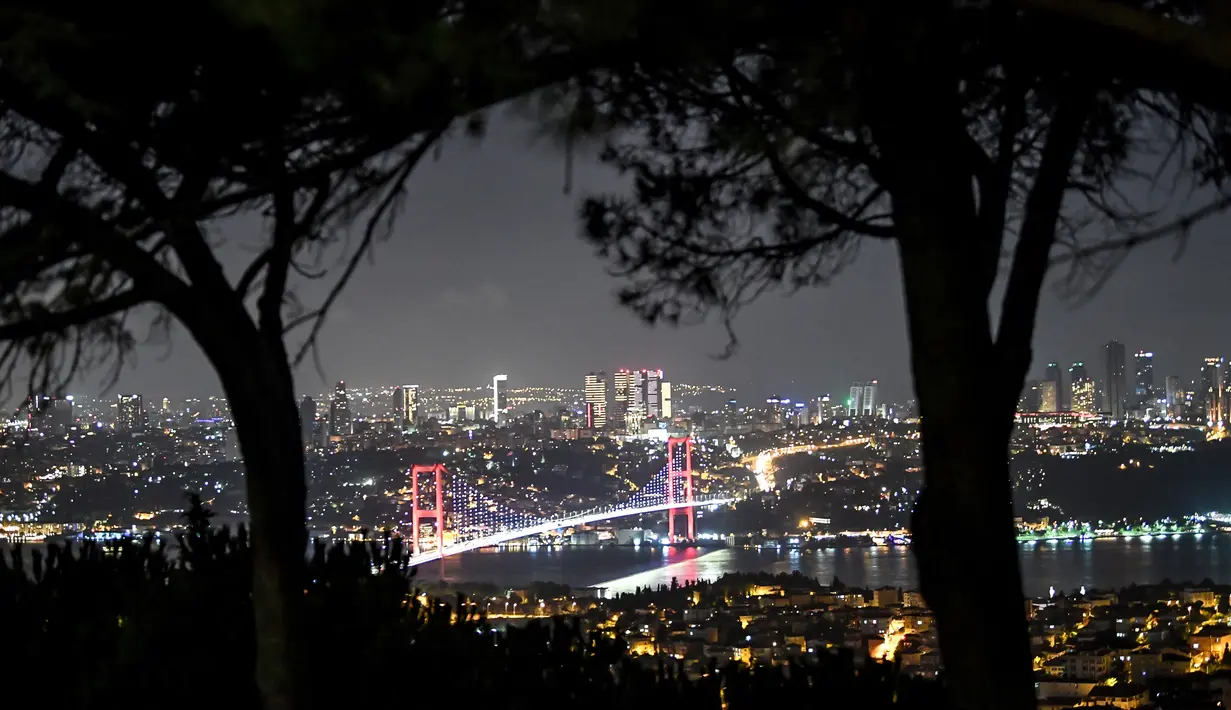 Pemandangan malam Jembatan Martir 15 Juli atau yang lebih dikenal dengan Jembatan Bosphorus di Istanbul, Turki, Jumat (24/8). Jembatan Bosporus selesai dibangun pada 30 Oktober 1973. (OZAN KOSE/AFP)