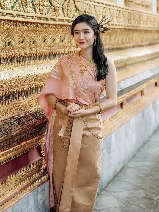 <p>Ia mengenakan pakaian tradisional Thailand yang disebut dengan chut thai. Febby mengenakan chut thai atasan pink dipadukan bawahan mirip songket warna coklat. [Instagram/@febbyrastanty]</p>