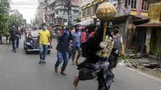Seorang pria berkostum dewa kematian Yamaraj berlari keliling mencari warga yang masih berkeliaran tanpa masker di tengah lockdown di Kolkata, India (24/4/2020). Dalam aksinya, pria tersebut memberikan imbauan kepada warga agar memakai masker di tengah wabah virus corona. (AFP/Dibyangshu Sarkar)