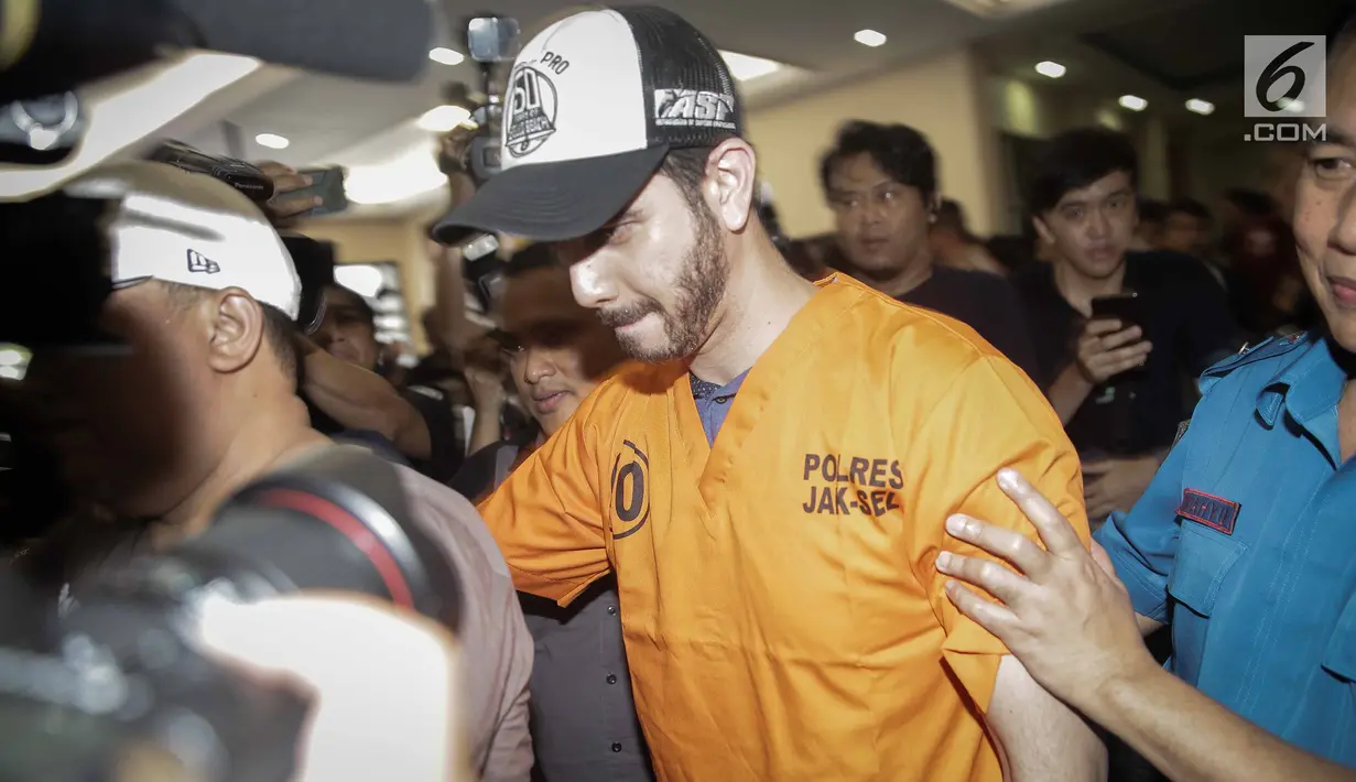 Aktor Fachri Albar dikawal petugas saat dihadirkan dalam gelar rilis di Polres Jakarta Selatan, Rabu (14/2). Selain itu ditemukan juga puntung ganja bekas pakai. (Liputan6.com/Faizal Fanani)