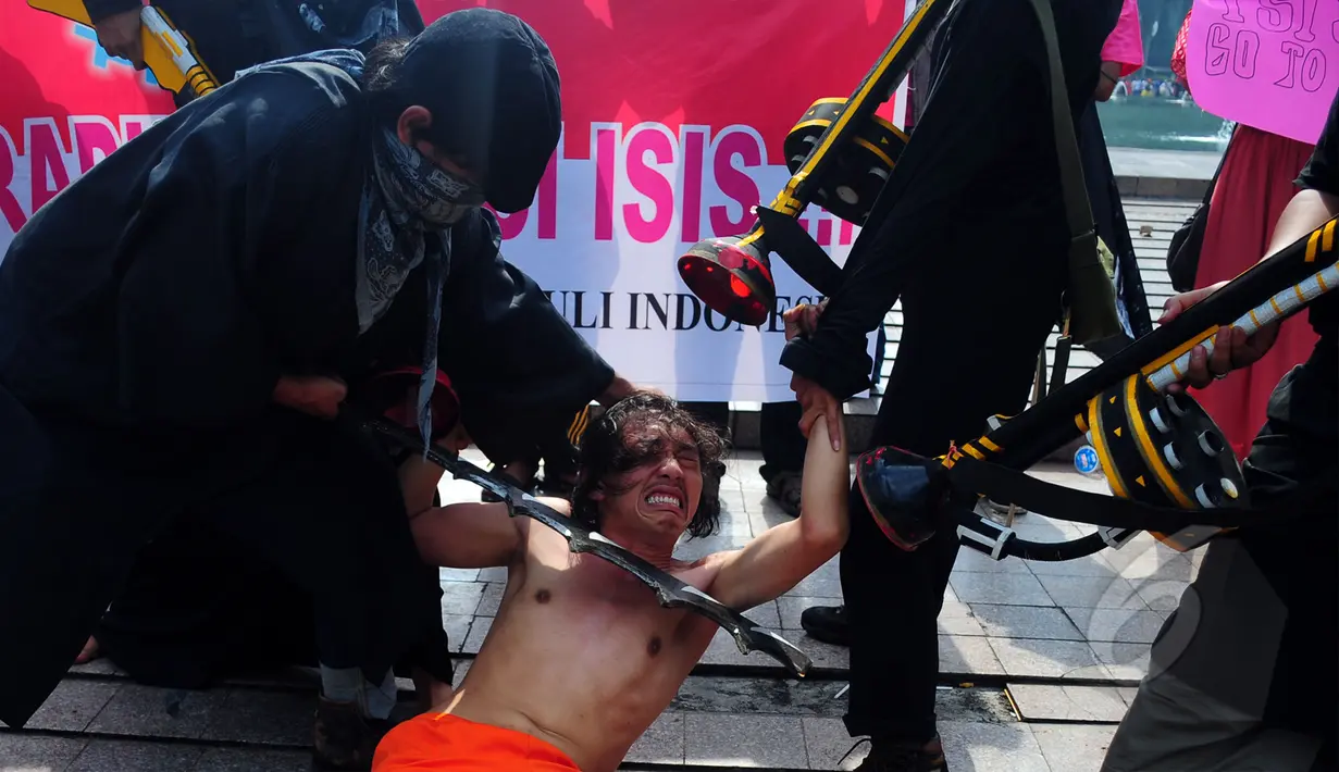 Sejumlah mahasiswa melakukan aksi menolak ISIS di Car Free Day, Bundaran HI, Jakarta, Minggu (15/3/2015). Mereka melakukan aksi teaterikal sebagai bentuk sindiran terhadap kekejaman ISIS. (Liputan6.com/Yoppy Renato) 