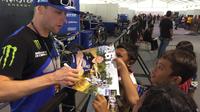 Crosser Monster Energy Yamaha Factory MXGP Team, Romain Febvre, memberikan tanda tangan untuk para penonton di paddok sirkuit BSB City, Mijen, Semarang, Minggu (14/7/2019). (Bola.com/Vincentius Atmaja)