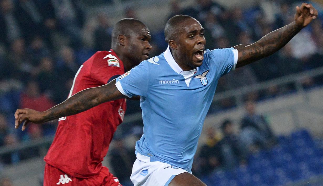 Pemain Lazio, Edson Braafheid (kanan) berebut bola dengan pemain Cagliari, Victor Ibarbo pada laga Liga Italia 2013/2014 di Olympic Stadium, Roma, 3 November 2014. Jersey Lazio musim 2014/2015 yang didominasi warna biru langit khas klub berjuluk Elang Ibu Kota tersebut terlihat tak berlogo sponsor. Mereka juga memadukan aksen putih pada lengan dan kerahnya. (AFP/Tiziana Fabi)