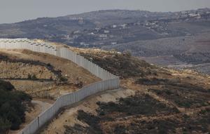 Sebuah foto yang diambil dari Israel memperlihatkan perbatasan yang memisahkan Israel utara dari Lebanon selatan, dengan desa Lebanon Ain Ebel terlihat di latar belakang pada 16 November 2025. Israel membangun tembok perbatasan baru di sepanjang garis perbatasan dengan Lebanon wilayah bagian Selatan. (Jalaa MAREY/AFP)