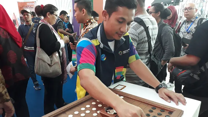 Seorang pengunjung asik memainkan salah satu Permainan Tradisional di Terminal 3 Bandara Internasional Soekarno Hatta, Kota Tangerang, Senin (27/8/2018).