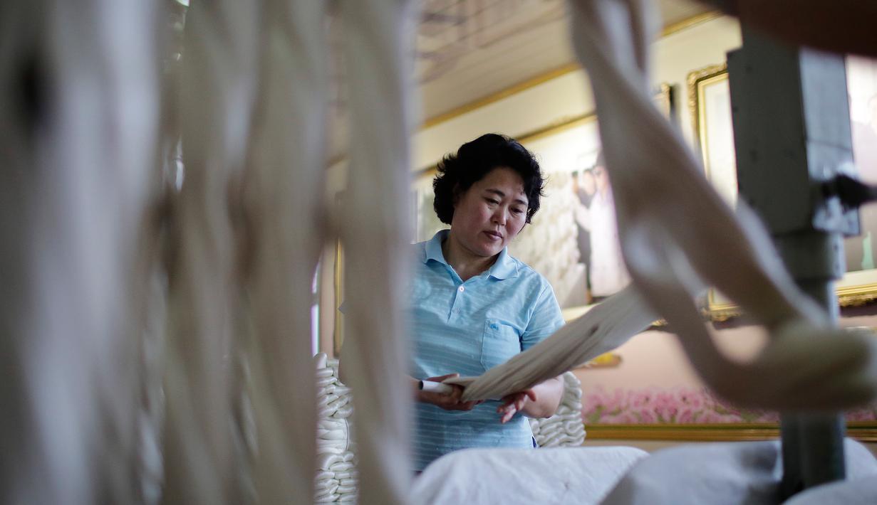 Seorang pekerja wanita menyelesaikan pekerjaannya di Kim Jong Suk Silk Mill, Pyongyang, Korea Utara (6/1). Pabrik ini mampu menghasilkan benang sutra sebanyak 200 ton. (AP Photo/Wong Maye-E)