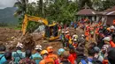 Hingga, Jumat (21/11/2025), ada 18 korban yang masih dalam pencarian. Tampak dalam foto, petugas penyelamat berkumpul di sekitar ekskavator selama operasi pencarian di lokasi longsor di Desa Situkung, Banjarnegara, Jawa Tengah, pada Kamis 20 November 2025. (DEVI RAHMAN/AFP)