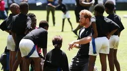 Pangeran Harry  berbincang dengan anak - anak di Durban , Afrika Selatan, Selasa (1/12). Harry dan  Pangeran Lerotholi Seeiso membuat organisasi amal yang bernama Sentebale. (REUTERS/Rogan Ward) 